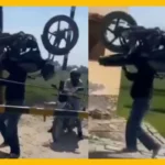 Man Hoists Bike Over Railway Barrier